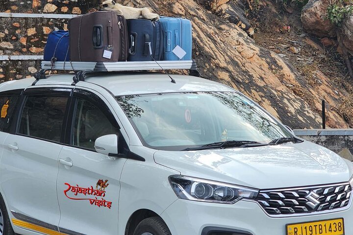 Chauffeur-driven Rajasthan taxi carrying luggage for Agra taxi service